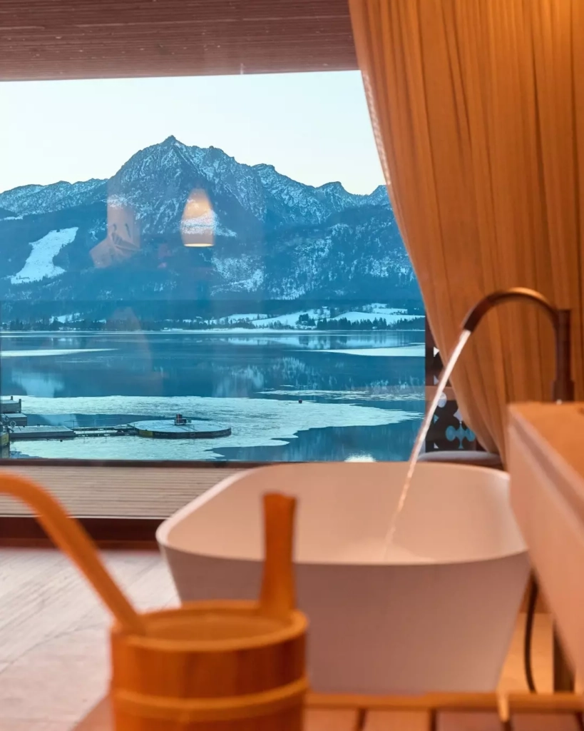 A hot tub in the spa area with a view of Lake Wolfgang and the mountains at the 4-star hotel.