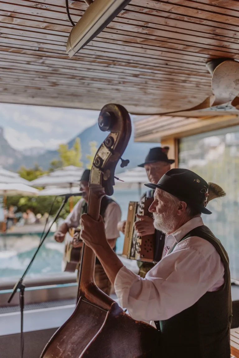Volksmusiker musizieren vor Infinity Pool und Seekulisse
